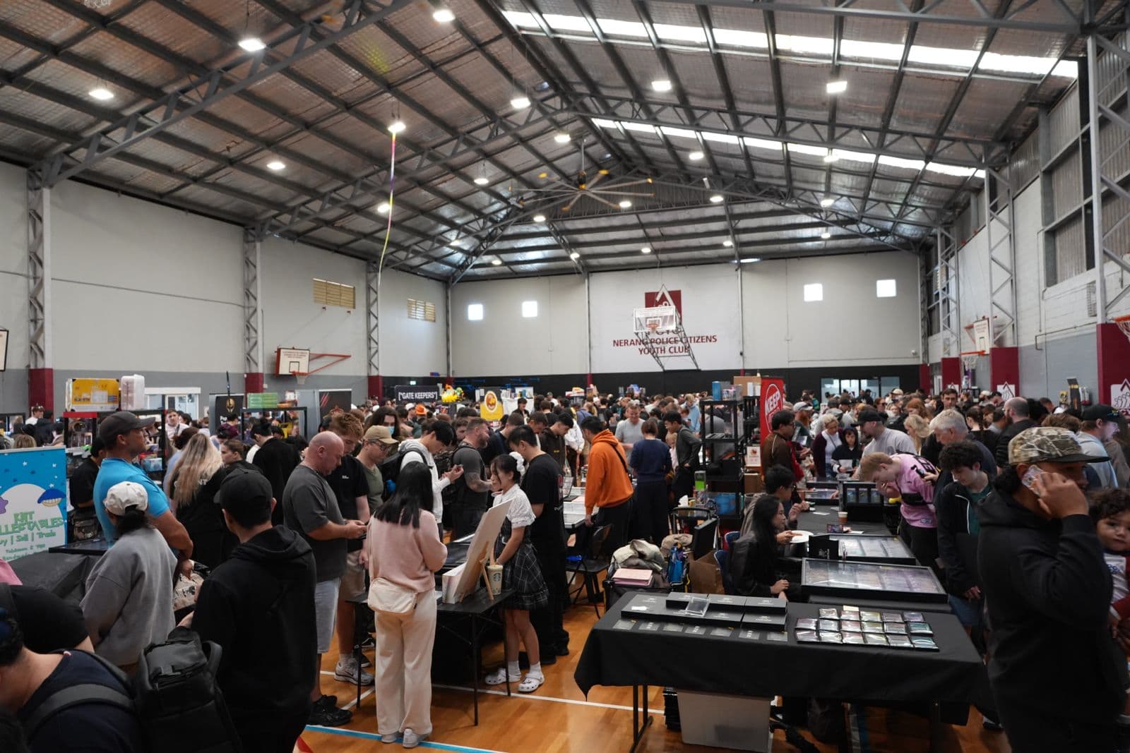 Collectors browsing vendor tables in a busy Collector’s Paradise event hall