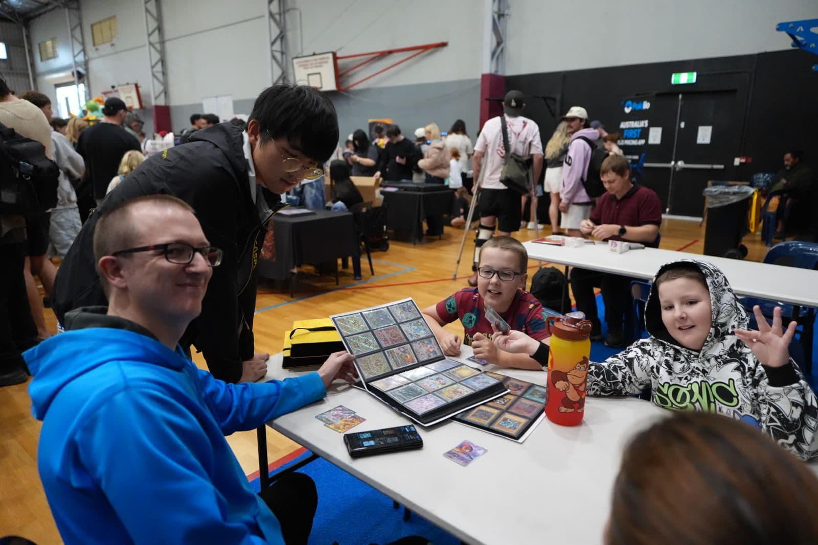 Event visitors sharing a trading card collection around a table